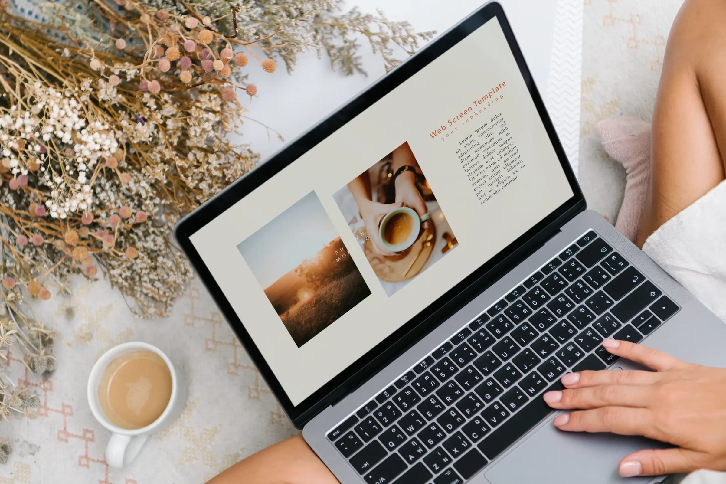 Laptop showing a web design next to a cup of coffee